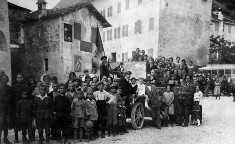 15b-Anni '20. Festa a Sospirolo,in primo piano una corriera della ditta Buzzatti e sullo sfondo quella della ditta Doglioni_martini che faceva servizio nella valle del Mis.jpg