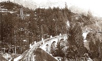 32b) Dopo Calalzo il trenino entrava in un boschetto e di seguito praticava un viadotto curvo sulla Valle Orsina mentre entrava nella galleria omonima (26 m.).jpg