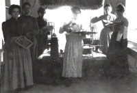 37) In primo piano Rosina, a sinistra con la famosa lavagnetta su cui scrivere i conti coi gessetti r Maria, al centro, ritratte agli inizi del Novecento col personale di servizio verso la sala da pranzo.jpg