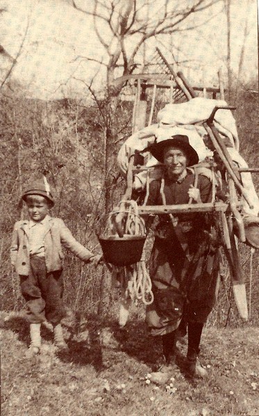 19-Dalla Cort Giovanna caricata  per andare sulle Mandre e Fortugn a portare a valle il fieno che in mattinata gli uomini avevano falciato.Con lei il piccolo Brancaleone Roberto '50..jpg